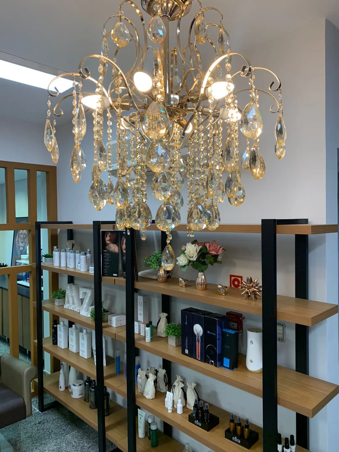 Lustre de cristal e prateleiras de produtos na Casa MZX